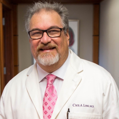 a man wearing glasses and smiling at the camera