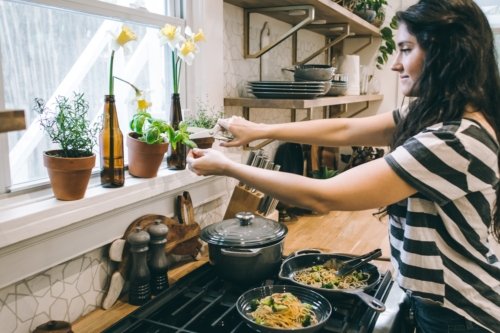 a woman cooking in a kitchen preparing food