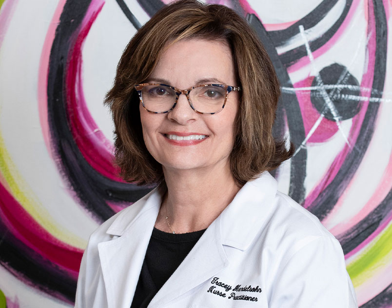 a person wearing glasses and smiling at the camera
