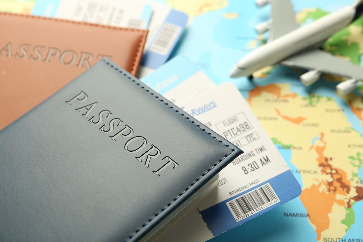 Two passports sit on top of a map with plane tickets sticking out of them
